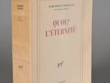 un vieux livre posé sur une table à côté d'un mur gris