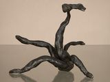 une sculpture en bronze représentant un homme tombant d'un arbre