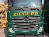 deux camions verts garés l'un à côté de l'autre sur un parking