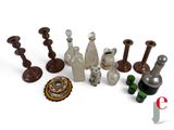 a lot of glass bottles and candlesticks on a white surface