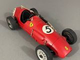 une vieille maquette de voiture de course rouge portant le numéro six à l'avant