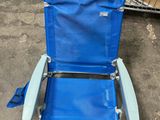 une chaise de plage bleue avec un rouleau de tissu posé sur le dossier