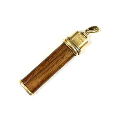 un gros plan d'un stylo en bois et en laiton sur fond blanc