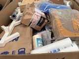 une boîte en carton remplie d'objets hétéroclites sur le sol