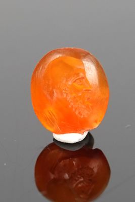 an orange jade ball sitting on top of a black surface