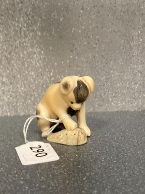 une petite figurine représentant un chien, à laquelle est accrochée une médaille