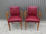 deux fauteuils en cuir rouge placés l'un à côté de l'autre devant un mur métallique
