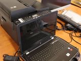 laptop computer sitting on top of a wooden desk next to a printer
