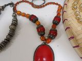 several necklaces and bracelets on a table next to a basket of beads
