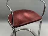un gros plan d'une chaise dont l'assise est rouge, posée sur une surface blanche