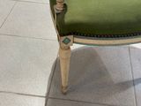 une chaise verte posée sur un sol carrelé