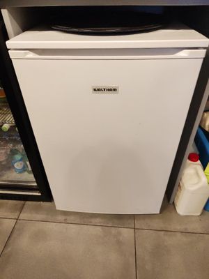 un petit réfrigérateur dans un coin de la cuisine