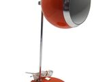 une photo d'une lampe de bureau rouge posée sur un pied métallique