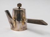 a silver teapot with a wooden handle on a white surface