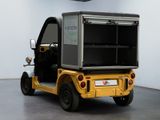 a small yellow cart with a black top in a room