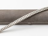 une photo d'un bracelet en argent posé sur un étui gris