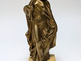 an antique bronze statue of a woman holding a basket