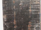 a metal door with holes in it on the wall
