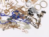 a pile of gold and silver jewelry on a white surface