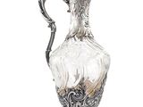 un vase en argent et en verre muni d'une anse et posé sur un socle