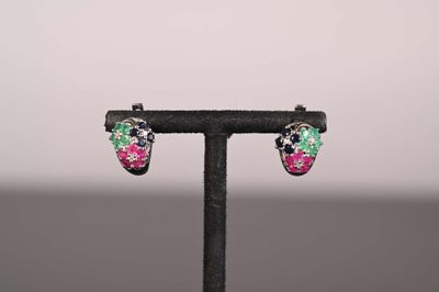 une paire de boucles d'oreilles multicolores posées sur un support noir