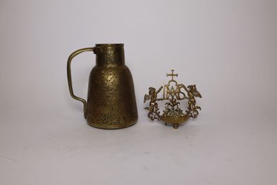 an image of a small brass pitcher next to a small brass candle holder