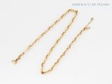 a close up of two gold chains on a white surface