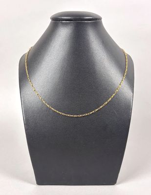 a gold chain necklace on a mannequin neck