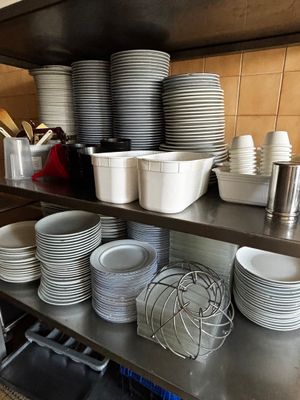 beaucoup d'assiettes et de bols sur les étagères de la cuisine