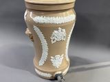 un vase marron et blanc avec un couvercle, posé sur une table