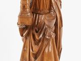 a wooden statue of a woman holding a bird and a castle