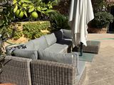 a patio with a couch and a table with an umbrella