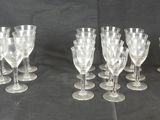 six clear wine glasses are lined up on a black background