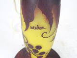 a yellow vase with a brown and black design on it