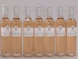 six bouteilles de vin sont alignées sur une surface blanche