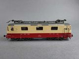 a red and yellow train car on a gray surface