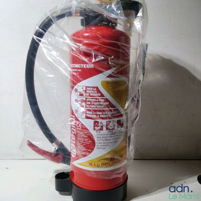 un extincteur emballé dans du plastique posé sur un comptoir
