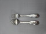 two silver spoons and a fork on a white surface
