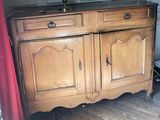 a wooden cabinet with two doors and a lamp on top of it