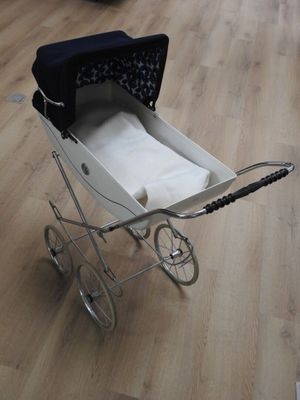 une poussette posée sur un plancher en bois