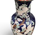 a vase that has a bird and flowers on it