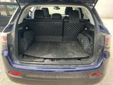 the back of a car with the trunk open and the back seats folded down
