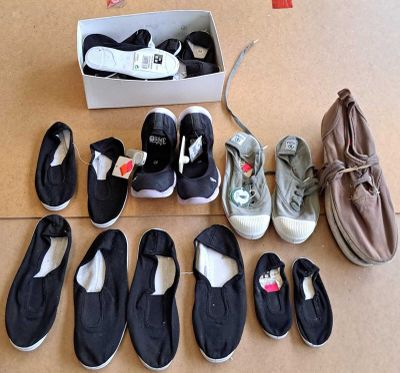 Plusieurs paires de chaussures sont disposées par terre à côté d'une boîte à chaussures.