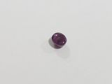 a close up of a purple gemstone on a white surface