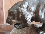 a statue of a bear on a rock in a room