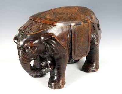 figurine d'éléphant en bois sculpté posée sur une surface blanche