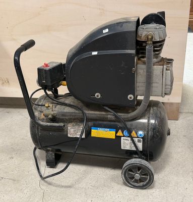 un compresseur d'air noir posé sur un chariot