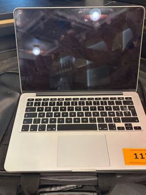 un ordinateur portable ouvert posé sur une valise, sur un lit