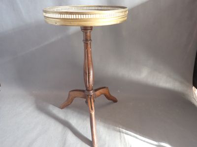 une petite table avec un plateau en verre posée sur un piètement en bois