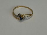 gros plan d'une bague en or avec une pierre bleue
